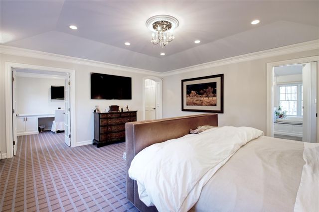 a spacious bedroom with a bed and a flat screen tv