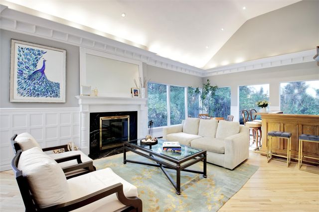 a living room with furniture a fireplace and a floor to ceiling window
