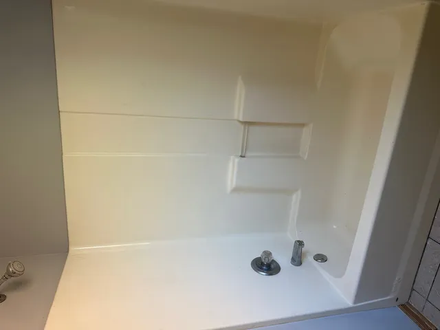 en empty room with windows and fireplace