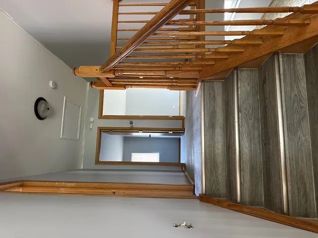 a hallway with stairs and a dishwasher