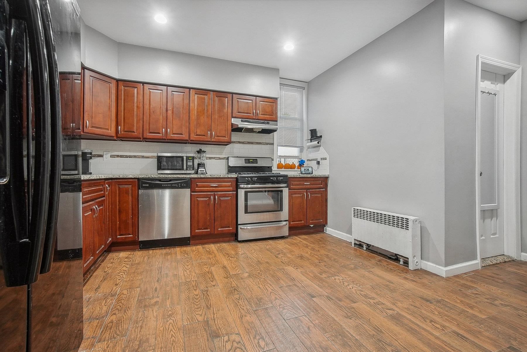 4 Rademan Place Jersey City, NJ 07310 - Photo 11 of 16 a kitchen with stainless steel appliances granite countertop a stove sink and cabinets