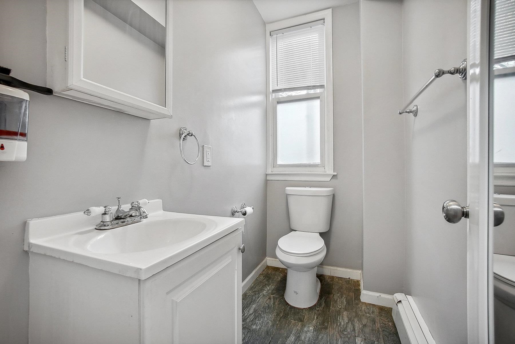 4 Rademan Place Jersey City, NJ 07310 - Photo 12 of 16 a bathroom with a sink toilet and a mirror