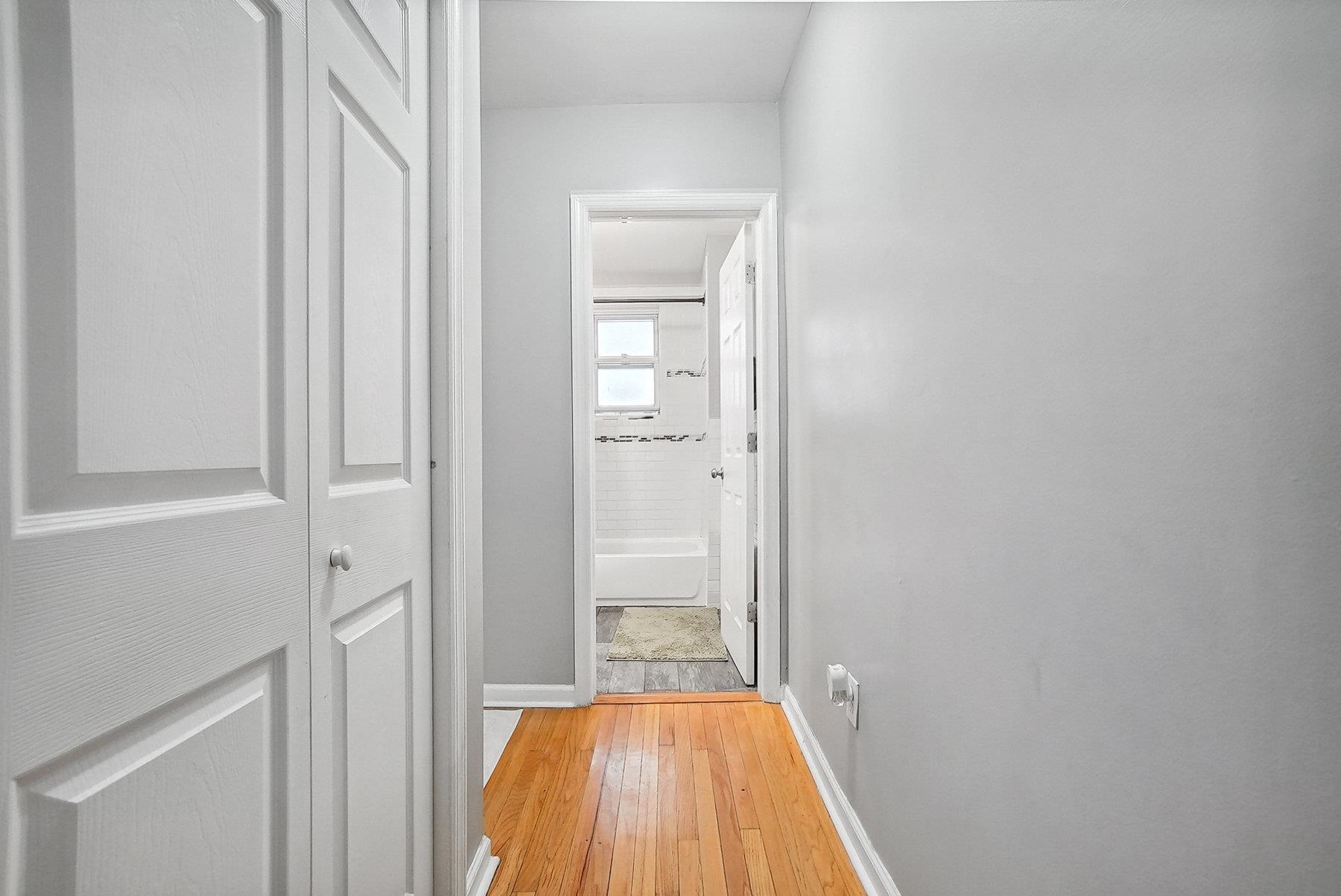 4 Rademan Place Jersey City, NJ 07310 - Photo 5 of 16 a view of a hallway with wooden floor and a bathroom