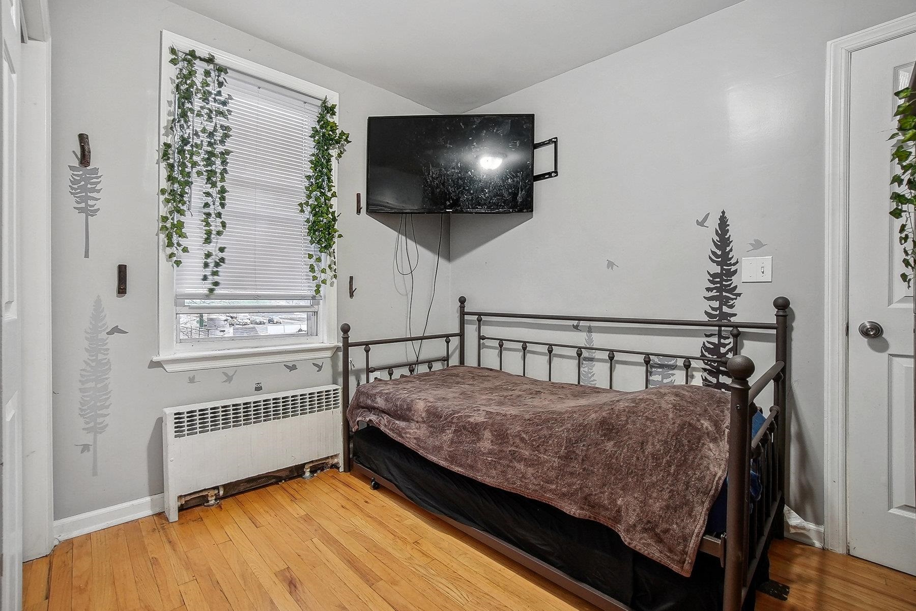 4 Rademan Place Jersey City, NJ 07310 - Photo 6 of 16 a bedroom with a bed and flat screen tv