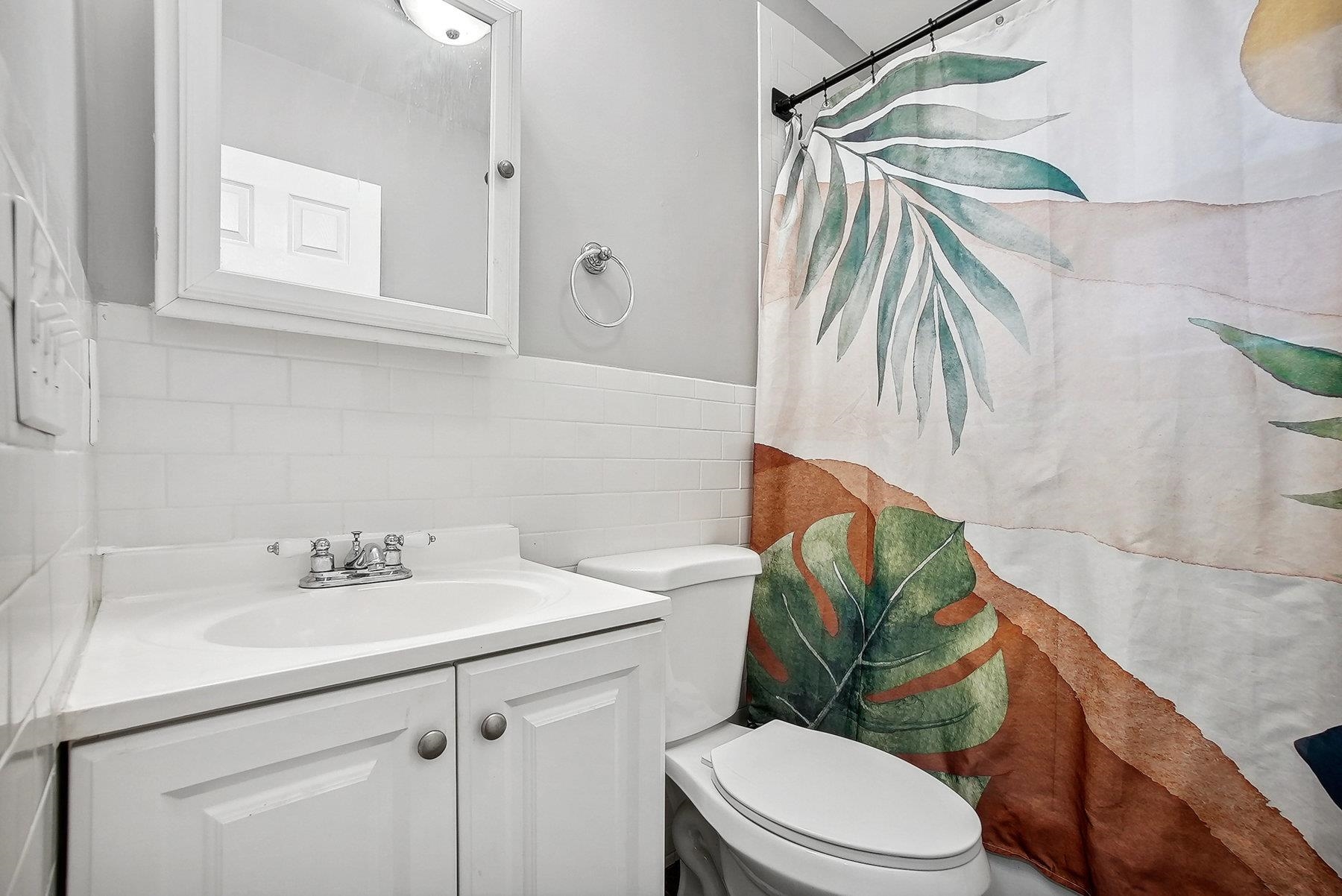 4 Rademan Place Jersey City, NJ 07310 - Photo 8 of 16 a bathroom with a sink toilet and a mirror