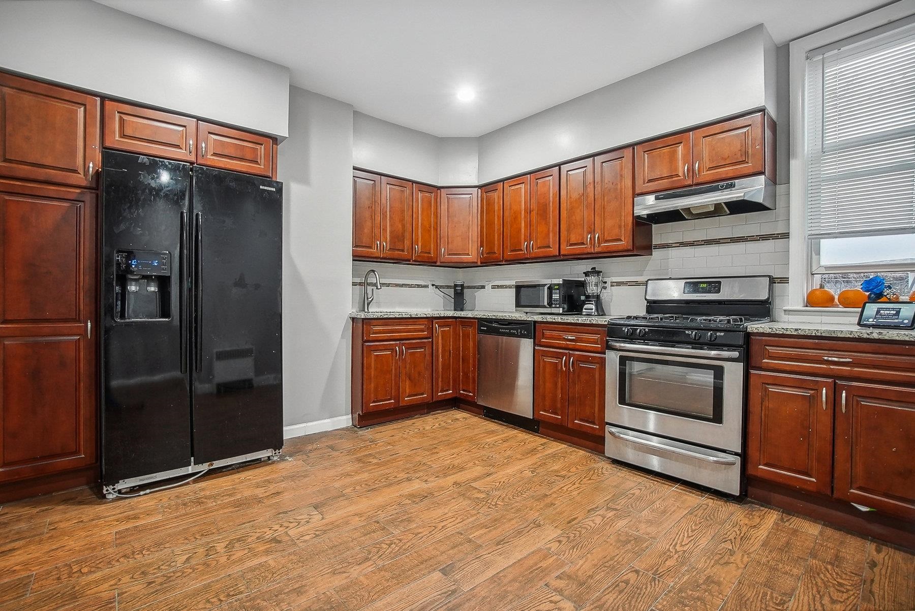 4 Rademan Place Jersey City, NJ 07310 - Photo 10 of 16 a kitchen with stainless steel appliances granite countertop a stove a refrigerator and a sink