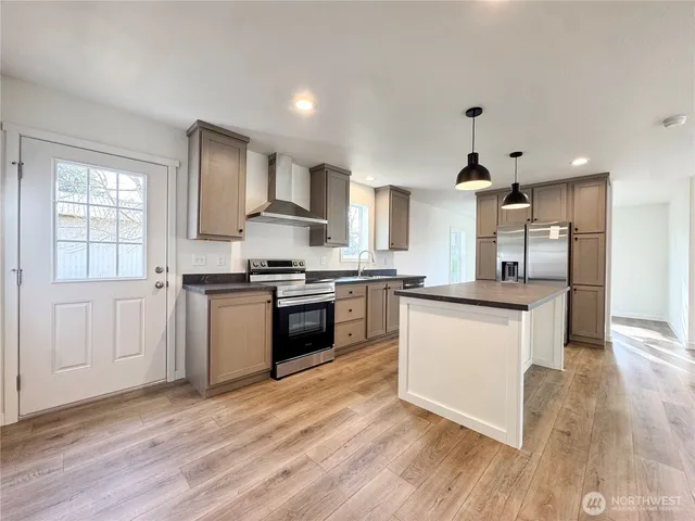 a kitchen with granite countertop a sink cabinets and stainless steel appliances