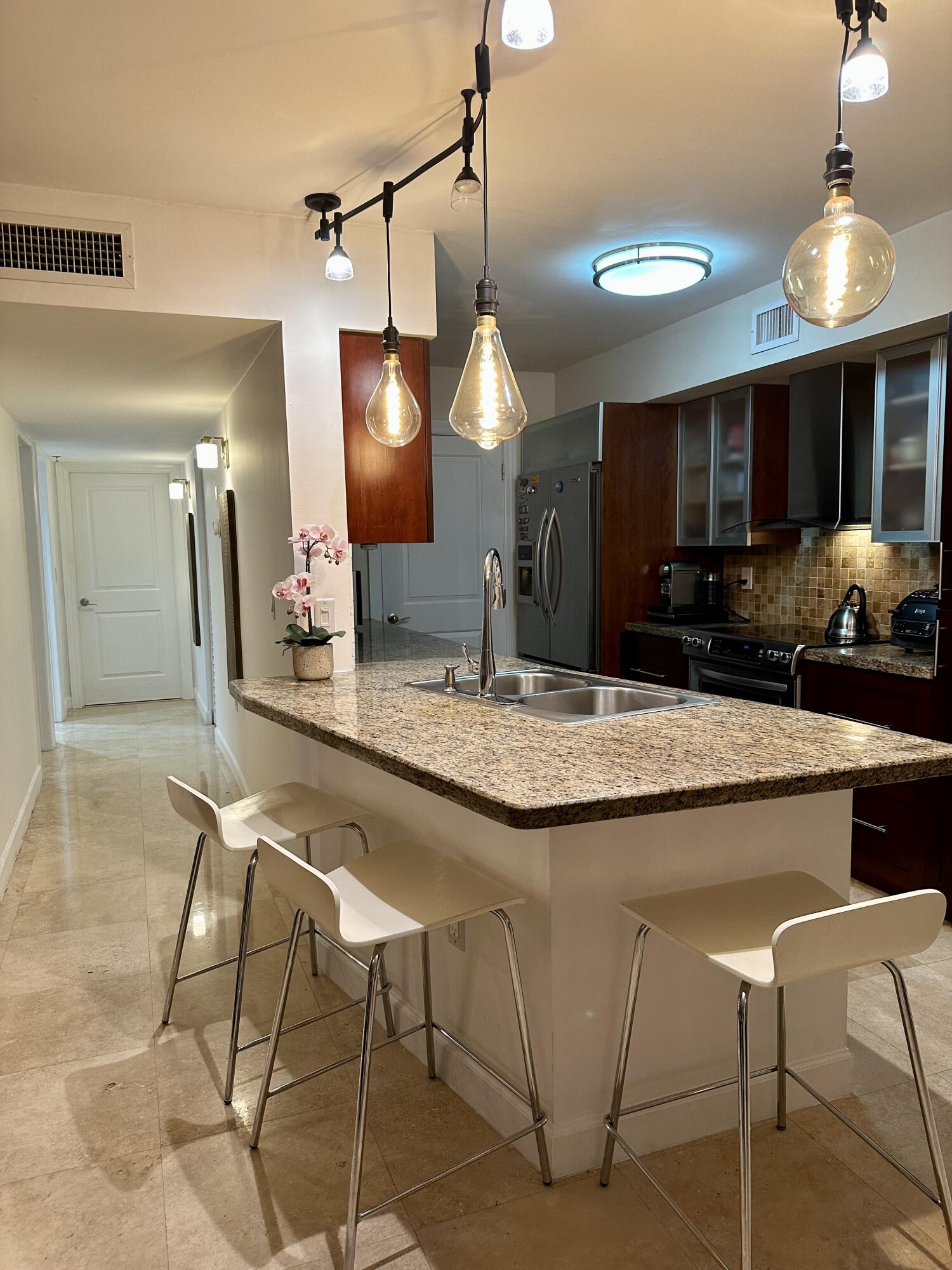 a kitchen with kitchen island granite countertop a sink a center island and cabinets