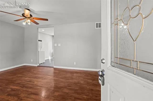 a view of a livingroom with wooden floor and white walls