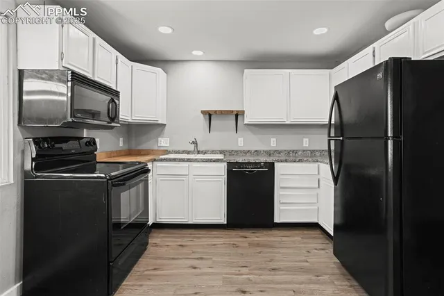 a kitchen with granite countertop a refrigerator stove and microwave