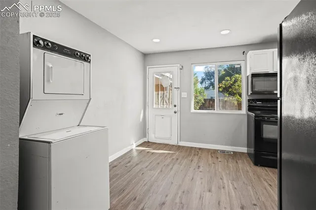 a view of a kitchen with wooden floor and electronic appliances