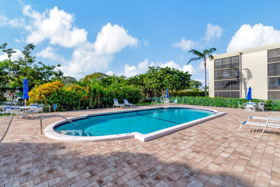 555 Banyan Tree Lane, Unit 302 Delray Beach, FL 33483 - Photo 12 of 69 a view of a swimming pool with a yard