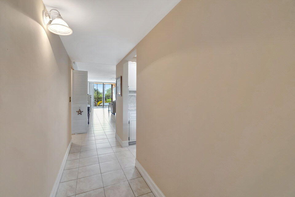 555 Banyan Tree Lane, Unit 302 Delray Beach, FL 33483 - Photo 37 of 69 a view of a hallway with wooden floor and a living room