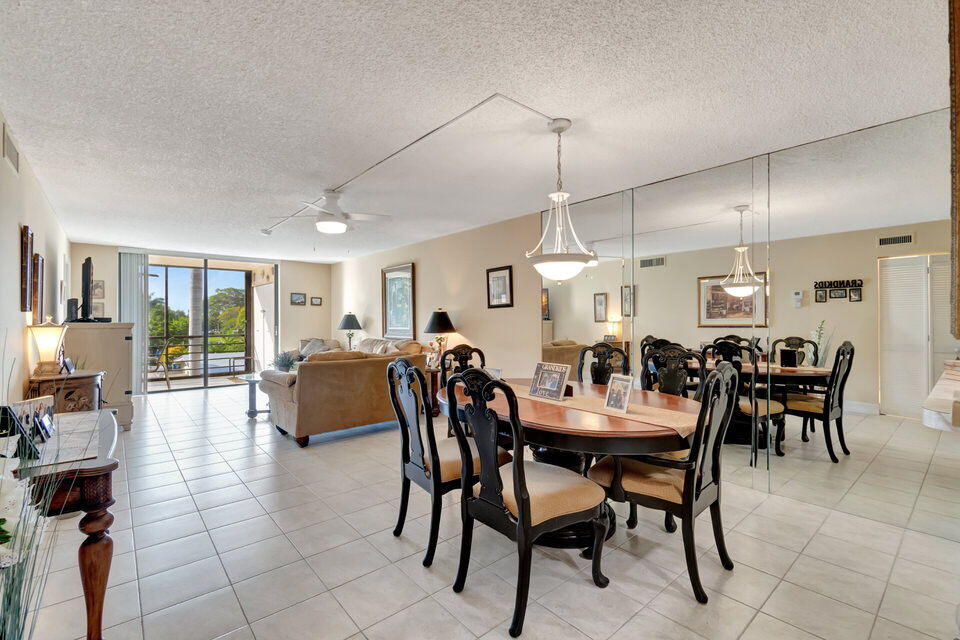 555 Banyan Tree Lane, Unit 302 Delray Beach, FL 33483 - Photo 38 of 69 a dining area with glass top table and chairs