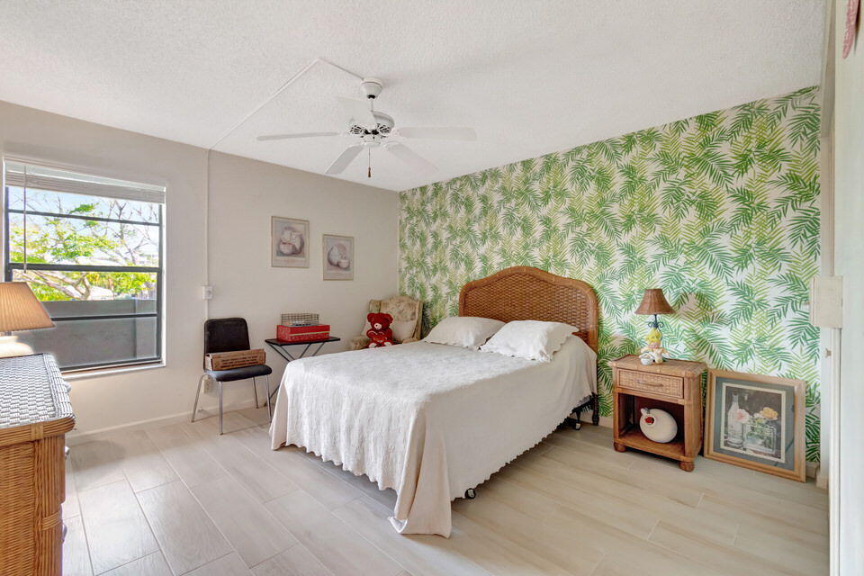 555 Banyan Tree Lane, Unit 302 Delray Beach, FL 33483 - Photo 57 of 69 a bedroom with a large bed and a tv