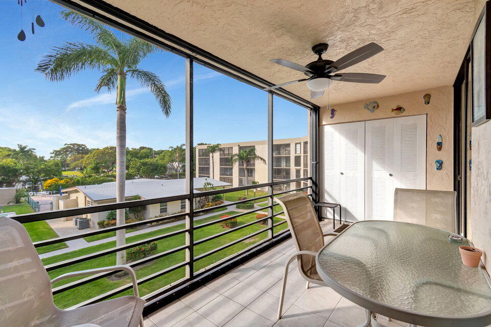 555 Banyan Tree Lane, Unit 302 Delray Beach, FL 33483 - Photo 7 of 69 a balcony with hardwood filled with table and chairs