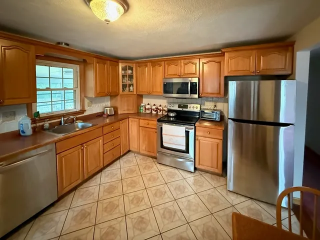 a kitchen with stainless steel appliances granite countertop a refrigerator sink and cabinets