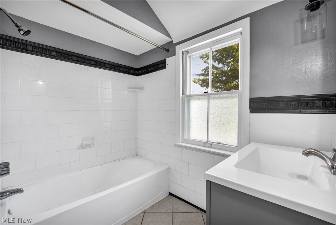 2313 North Taylor Road Cleveland Heights, OH 44112 - Photo 24 of 32 Bathroom featuring a white subway tile tub surround, white bathtub, and a window with privacy glass