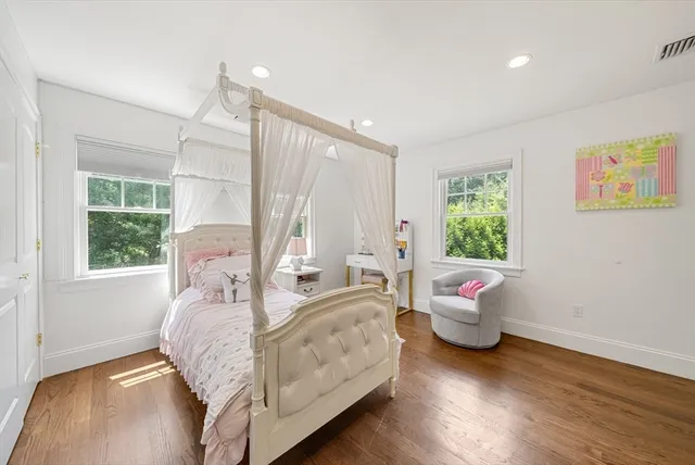 a bedroom with a bed large window with table and chairs