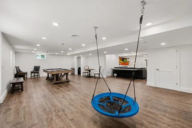 a room with wooden floor and pool table