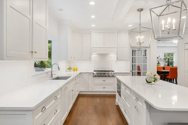 a large white kitchen with lots of counter space a sink and appliances