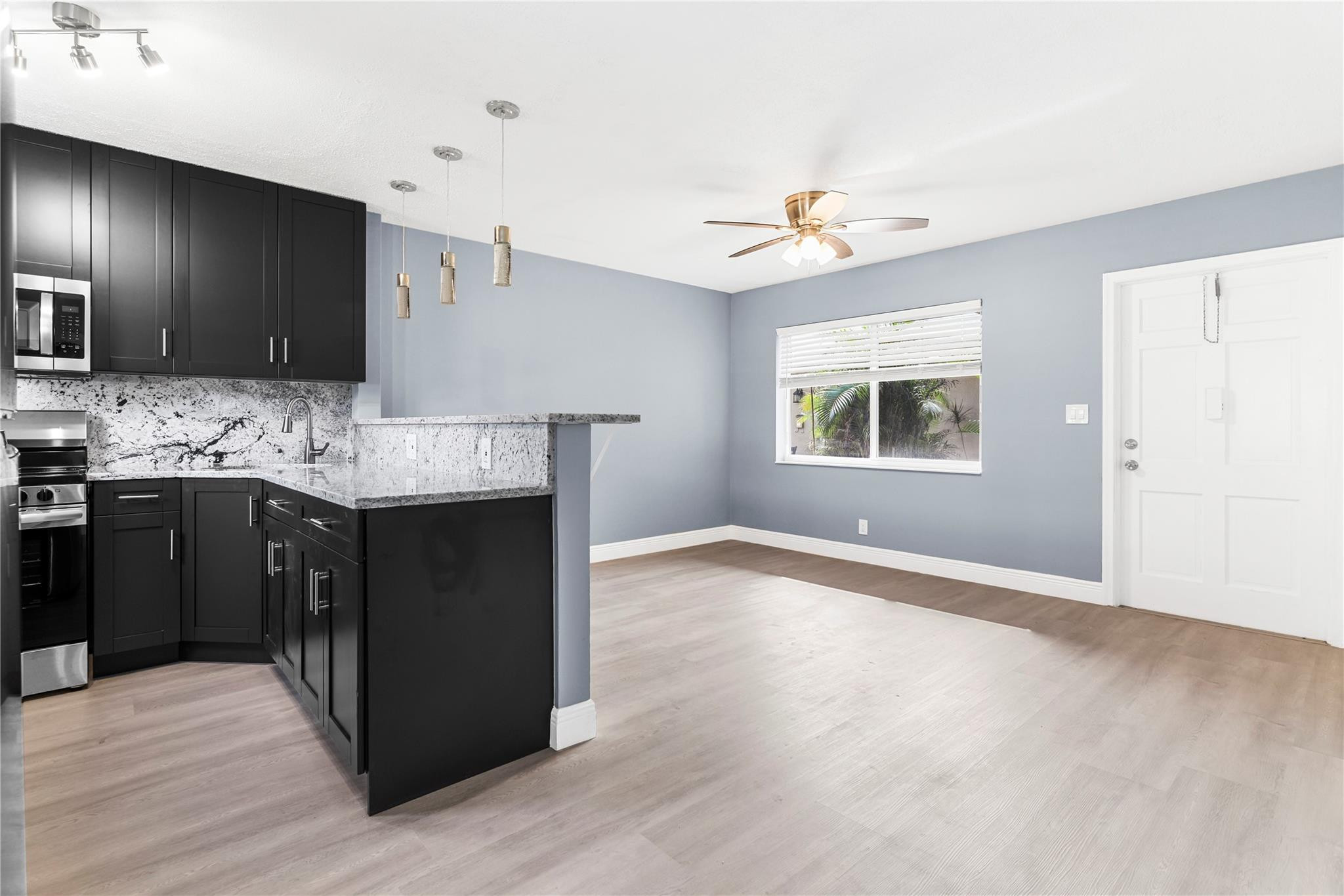 4751 Northeast 21st Terrace, Unit 3 Lighthouse Point, FL 33064 - Photo 1 of 18 a kitchen with kitchen island granite countertop a sink appliances and cabinets