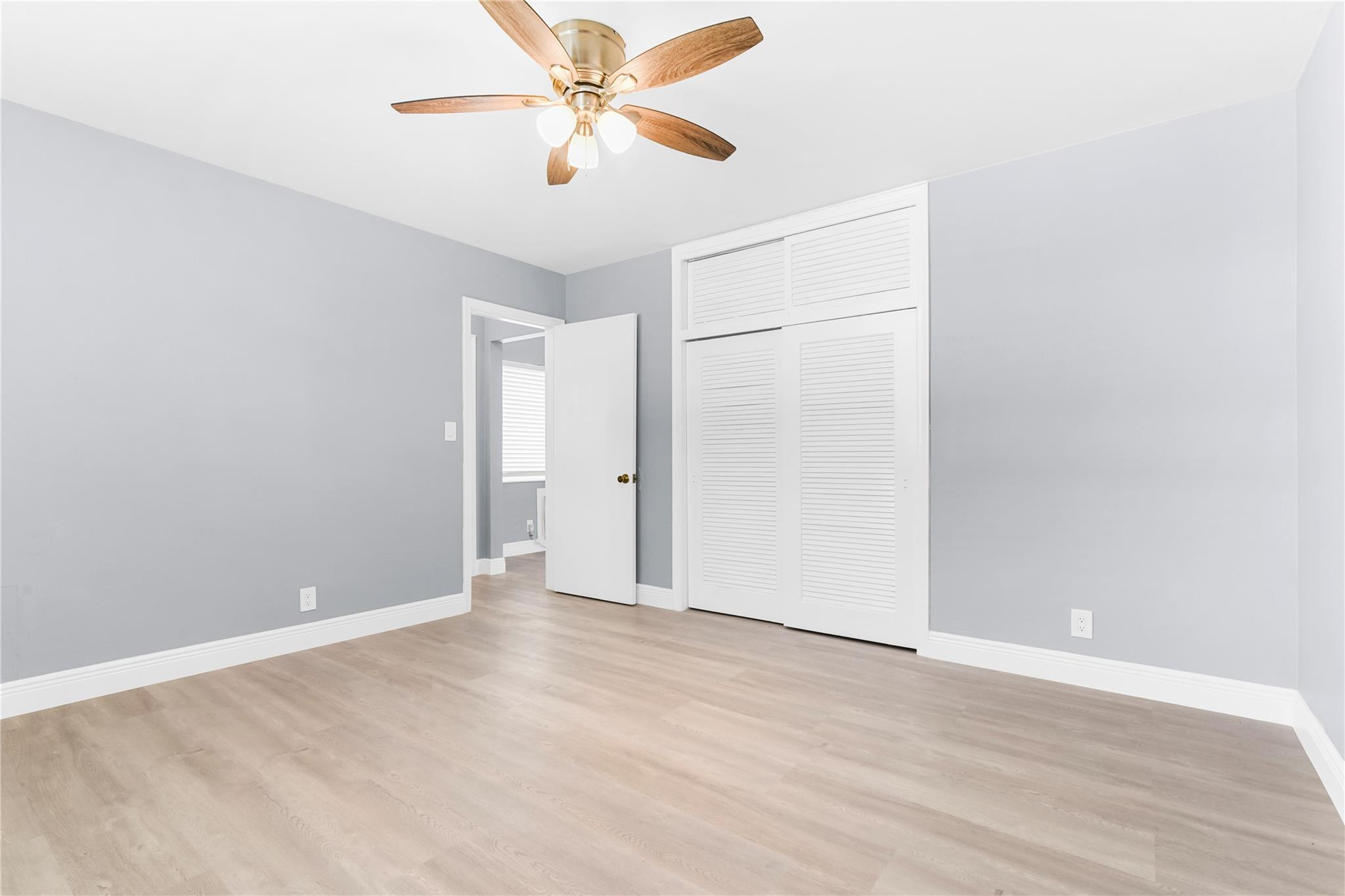 4751 Northeast 21st Terrace, Unit 3 Lighthouse Point, FL 33064 - Photo 14 of 18 an empty room with wooden floor closet and ceiling fan