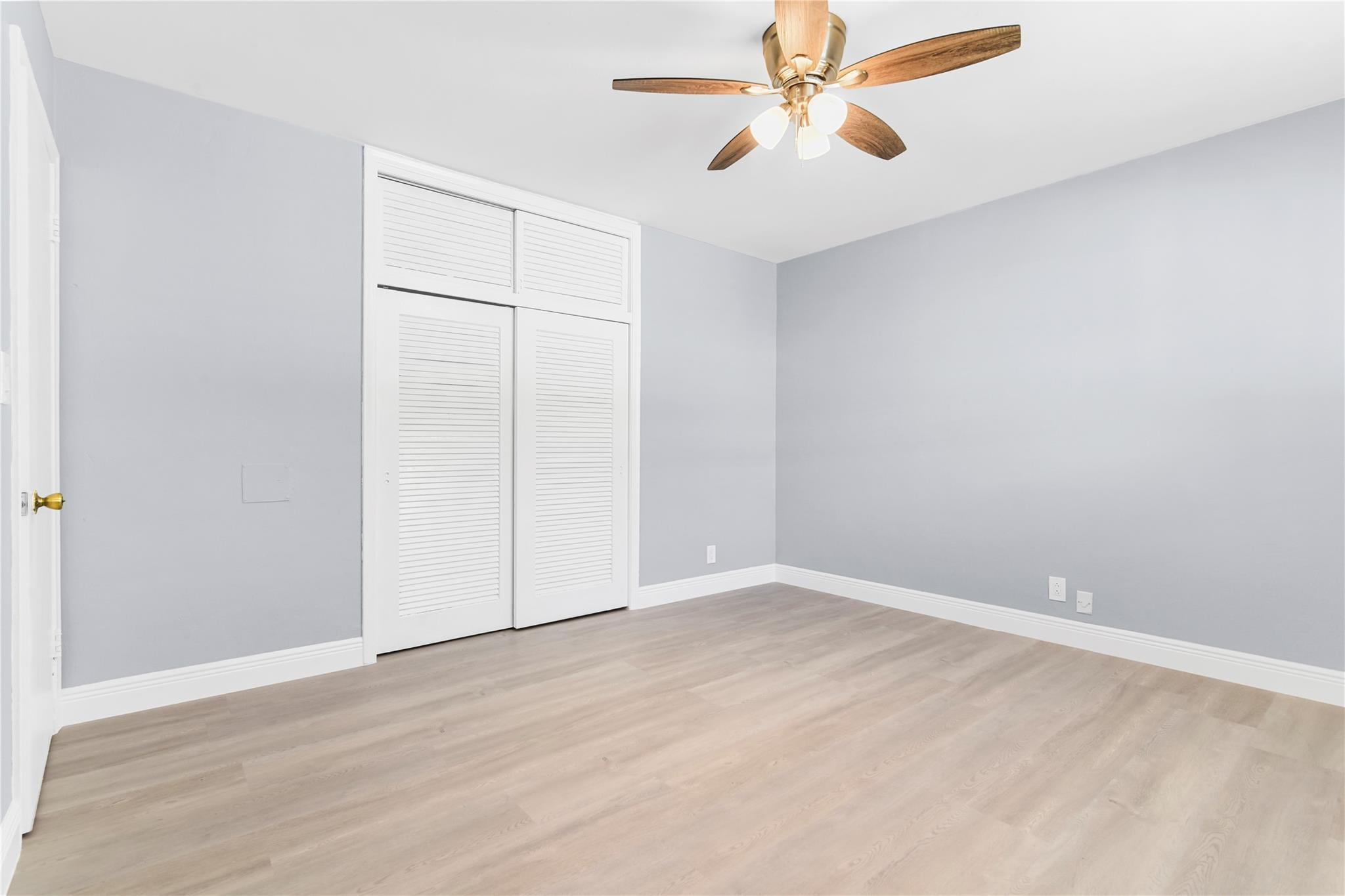 4751 Northeast 21st Terrace, Unit 3 Lighthouse Point, FL 33064 - Photo 15 of 18 an empty room with a ceiling fan and wooden floor