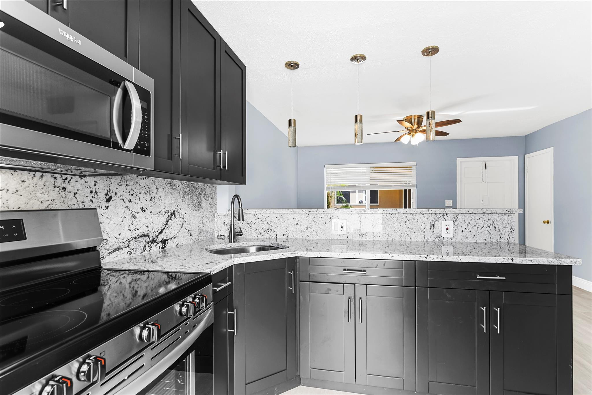 4751 Northeast 21st Terrace, Unit 3 Lighthouse Point, FL 33064 - Photo 7 of 18 a kitchen with granite countertop a sink and stove top oven