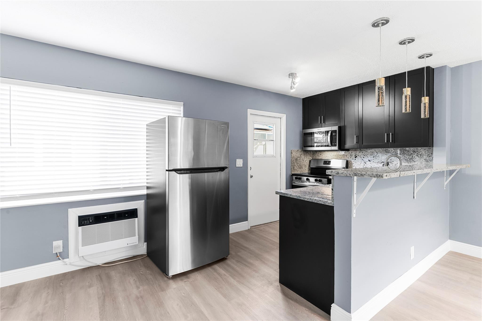4751 Northeast 21st Terrace, Unit 3 Lighthouse Point, FL 33064 - Photo 8 of 18 a kitchen with stainless steel appliances kitchen island granite countertop a refrigerator stove and oven