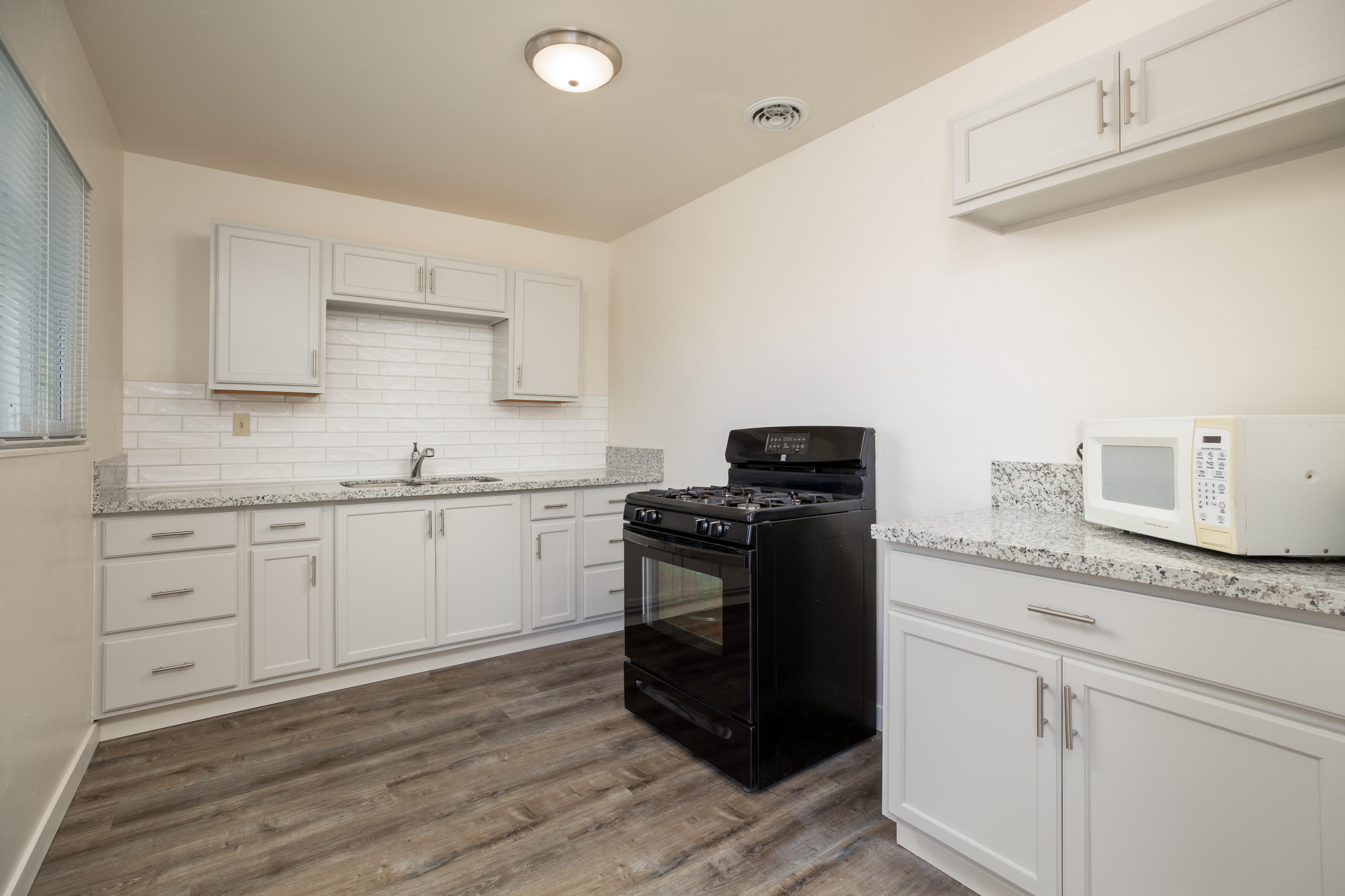 248 North Norma Street Ridgecrest, CA 93555 - Photo 7 of 17 a kitchen with granite countertop white cabinets and stainless steel appliances