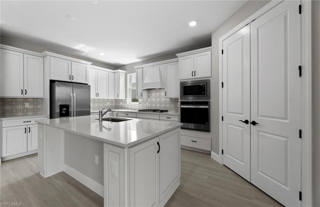 42533 Little Ridge Road Punta Gorda, FL 33982 - Photo 27 of 50 a kitchen with kitchen island a sink stainless steel appliances and cabinets