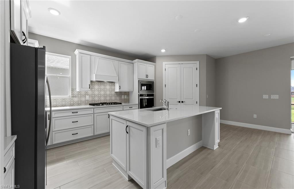 42533 Little Ridge Road Punta Gorda, FL 33982 - Photo 28 of 50 a kitchen with white cabinets and stainless steel appliances