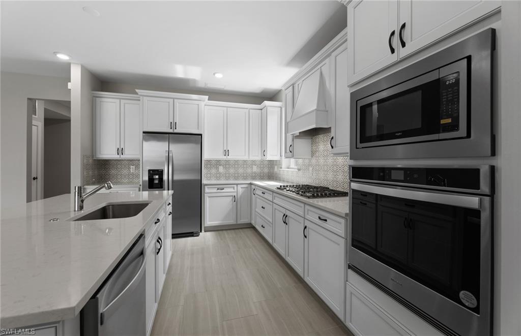 42533 Little Ridge Road Punta Gorda, FL 33982 - Photo 30 of 50 a kitchen with stainless steel appliances granite countertop a stove top oven a sink and a refrigerator
