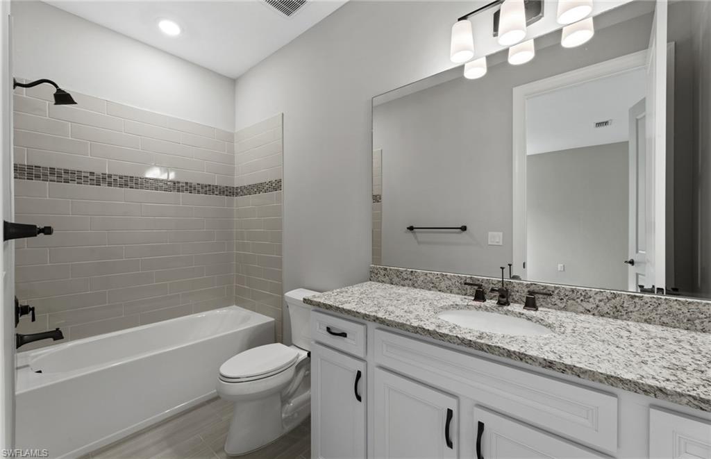 42533 Little Ridge Road Punta Gorda, FL 33982 - Photo 36 of 50 a bathroom with a granite countertop sink a toilet and shower