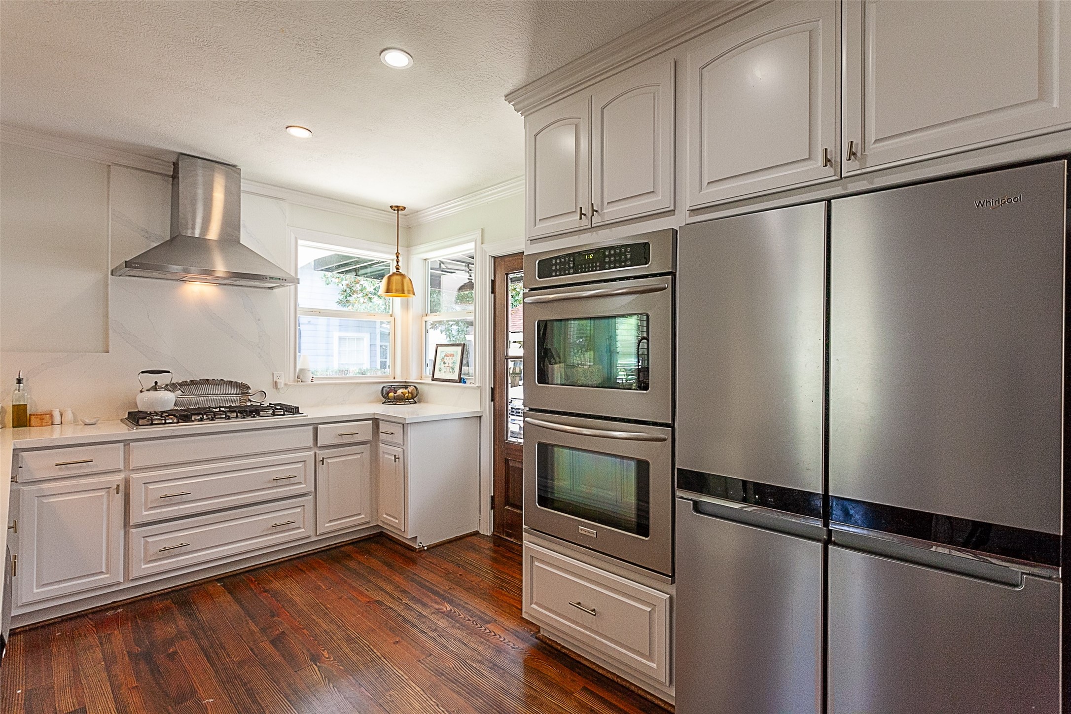 260 Manor Street Beaumont, TX 77706 - Photo 19 of 50 a kitchen with stainless steel appliances granite countertop a refrigerator a stove and white cabinets with wooden floors
