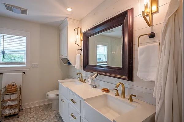a bathroom with a sink double vanity and a toilet