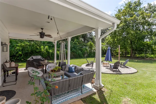 a view of a patio with a table chairs and a backyard