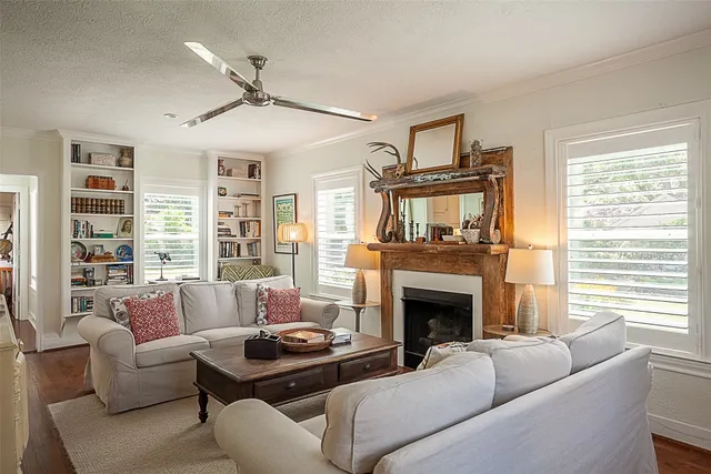 a living room with furniture a fireplace and a large window