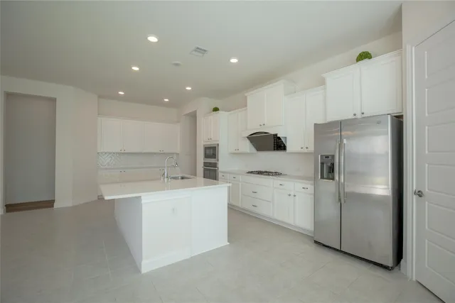 a kitchen with white cabinets and stainless steel appliances