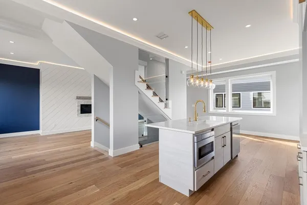 a kitchen with stainless steel appliances granite countertop a stove and a wooden floors