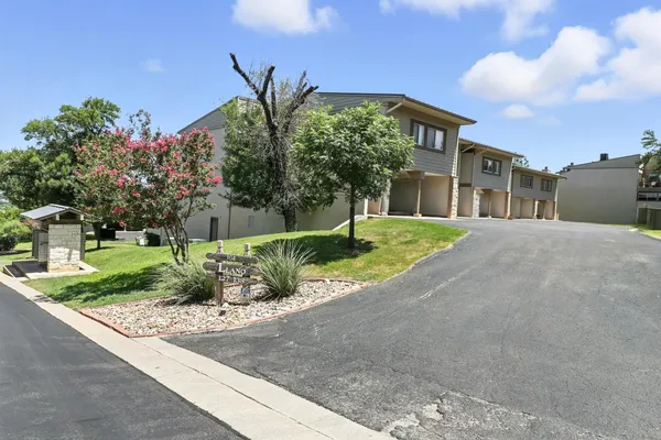 a view of a house with a yard and potted plants