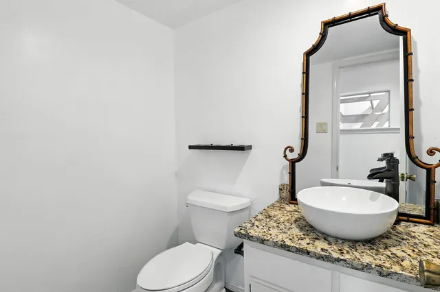 a room with a granite countertop toilet and sink