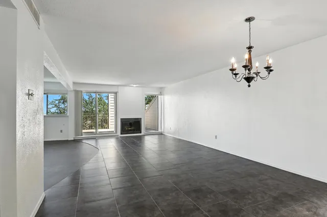 a view of a livingroom with a chandelier fan and windows