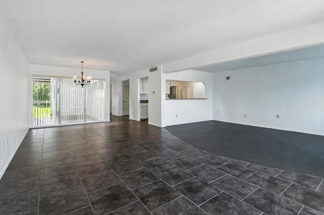 an empty room with windows and cabinet