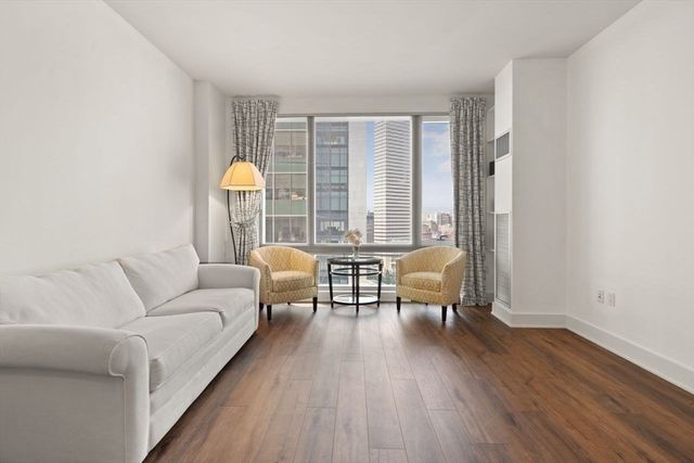 a view of a hallway with a room and wooden floor