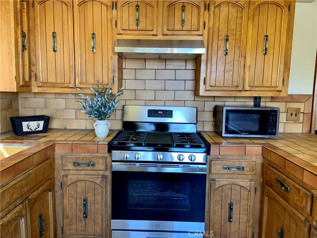 5507 Zermatt Drive Wrightwood, CA 92397 - Photo 11 of 31 a kitchen with stainless steel appliances granite countertop a stove and a microwave