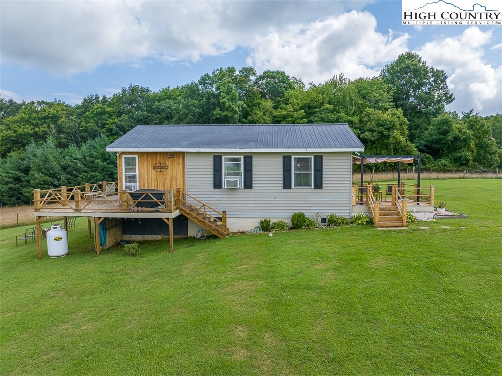 2411 Glade Valley Road Sparta, NC 28675 - Photo 33 of 50 a view of a house with a backyard and a patio