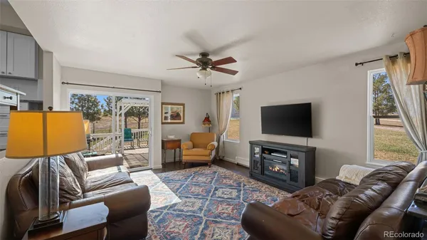 a living room with furniture a flat screen tv and a large window