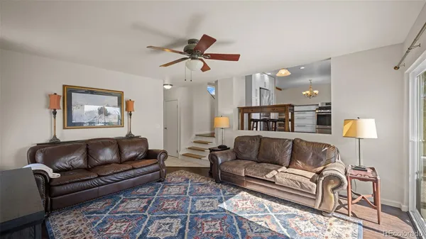 a living room with furniture and a ceiling fan